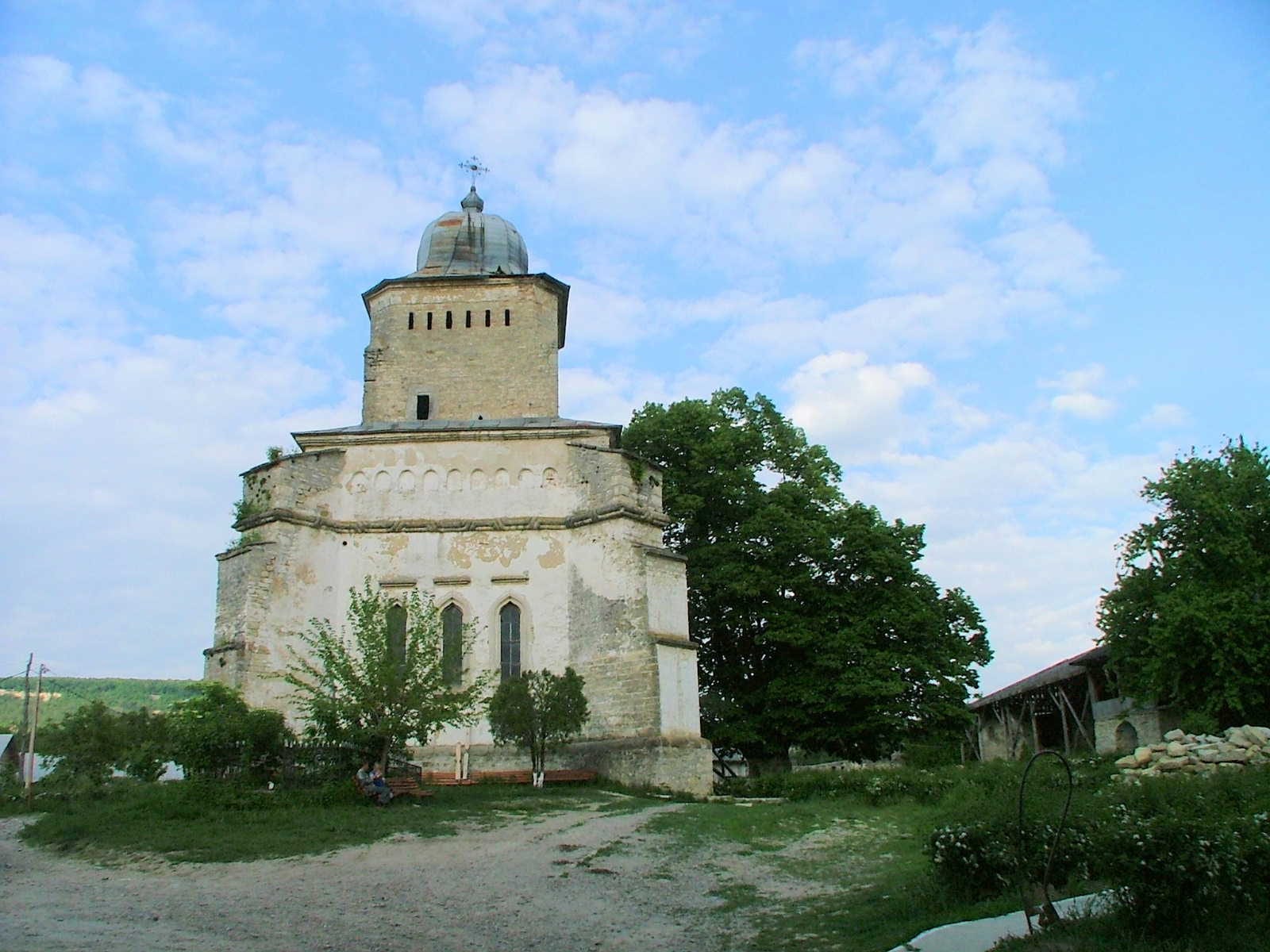 Biserica de piatră „Sfântul Gheorghe” a Mănăstirii Bârnova, cu turlă înaltă și ferestre gotice, sub cer cu nori
