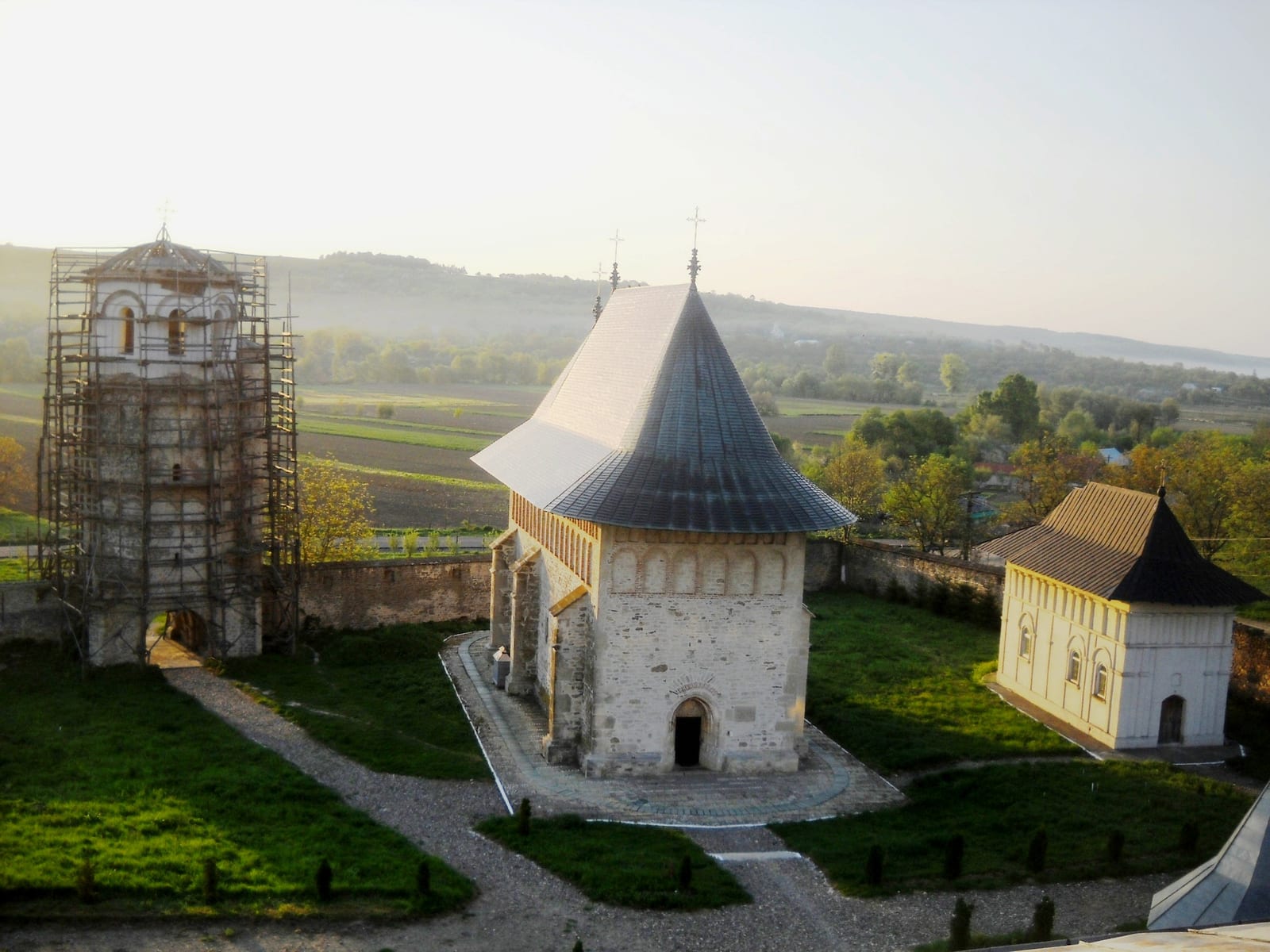 Ansamblul Mănăstirii Dobrovăț văzut de sus: biserica, turnul-clopotniță și paraclisul, în poiana de codru